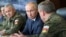 FILE - Russian President Vladimir Putin, center, and Russian Defense Minister Sergei Shoigu, left, attend the main stage of the Kavkaz-2020 strategic command-and-staff exercises at the Kapustin Yar training ground, Russia, Sept. 25, 2020.