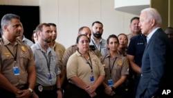 美国总统拜登在佛罗里达州的迈阿密海滩会见现场急救人员，此前他们在迈阿密郊区瑟夫塞德上周倒塌的一幢公寓大楼废墟上进行搜救工作。（2021年7月1日）