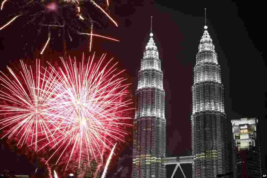 Fireworks explode in front of Malaysia's landmark building, Petronas Twin Towers, during the New Year's Eve celebration in Kuala Lumpur, Malaysia, Friday, Jan. 1, 2016.