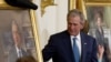 Former President George W. Bush and former first lady Laura Bush, right, unveil their portraits in the East Room of the White House in Washington, Thursday, May 31, 2012