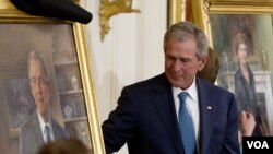 Former President George W. Bush and former first lady Laura Bush, right, unveil their portraits in the East Room of the White House in Washington, Thursday, May 31, 2012