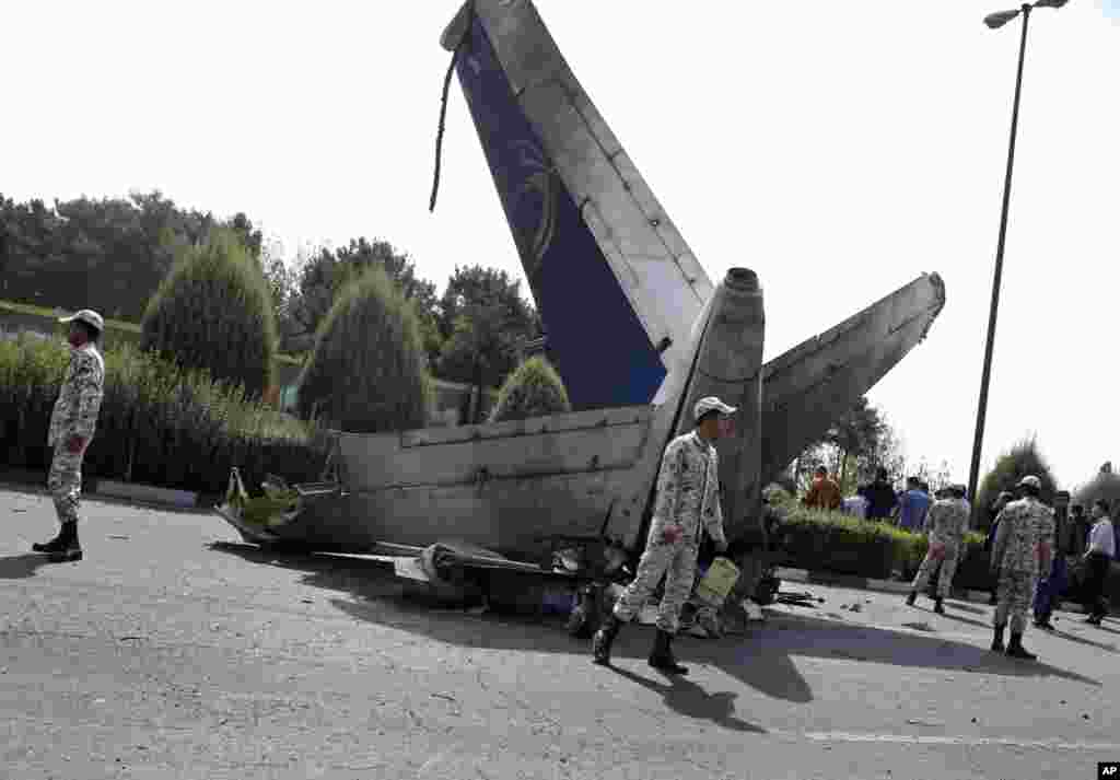 سربازان سپاه پاسداران در اطراف لاشه هواپیما نگهبانی می&nbsp; دهند. هواپیما از نوع ایران-۱۴۰ بود که در پروازهای کوتاه داخلی مورد استفاده قرار می گیرد. ده فروند از این هواپیما در ایران ساخته شده که تا به حال دو فروند آن سقوط کرده است - تهران، ۱۹ مرداد ۱۳۹۳ &nbsp;