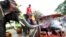 FILE - An elephant blows water from its trunk onto tourists in Ayutthaya province, central Thailand. A recent report by World Animal Protection found that Thailand is home to three-quarters of all elephants kept in captivity for entertainment purposes.