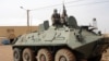 Fighters of the Islamic group, the Movement for Oneness and Jihad in West Africa [MUJAO] - an Al-Qaida offshoot - stand guard on a tank abandoned by the Malian Army, near Gao airport, Mali, August 7, 2012.