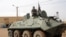 Fighters of the Islamic group, the Movement for Oneness and Jihad in West Africa (MUJAO) - an Al-Qaida offshoot - stand guard on a tank abandoned by the Malian Army, near Gao airport, Mali, August 7, 2012.
