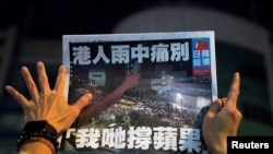 一名苹果日报的支持者手拿最后一期的苹果日报（路透社2021年6月24日）