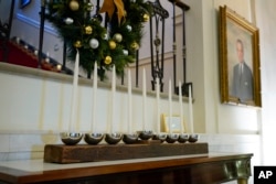 A menorah that was built by White House carpenters from wood that was removed during a Truman-era renovation is on display in Cross Hall of the White House during a press preview of holiday decorations at the White House on November 28, 2022, in Washington. (AP Photo/Patrick Semansky)