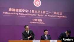 资料照：香港特首 李家超（中）率领律政司司长林定国（左）及保安局局长邓炳强2024年1月30日召开记者会，正式宣布展开为期29日的《基本法》23条立法公众咨询。 (美国之音/汤惠芸)