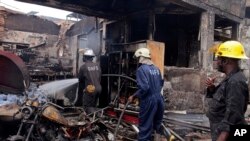 Des pompiers combattent le feu dans une station d’essence où une explosion s’est déclarée à Accra, Ghana, 4 juin 2015.