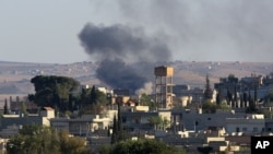 Asap tampak mengepul akibat serangan artileri di kota Kobani, Suriah (1/10).