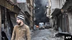 一名叙利亚男子走路穿过曾经由反政府武装控制的阿勒颇市的萨拉丁区（2016年12月23日）
