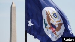 미국 워싱턴 국무부 건물에 걸린 국무부기 뒤로 워싱턴 기념탑이 보인다.