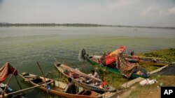 A Kashmiri fisherman cooks food inside his anchored boat on the shore of the Dal Lake in Srinagar, Indian controlled Kashmir, Oct. 2, 2019. 