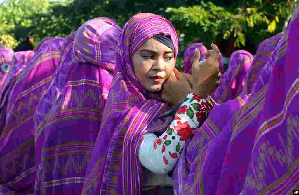 ស្រ្តី​ម្នាក់​សារ៉េ​ស្បៃរុំ​ក្បាល​នៅ​អំឡុងពេល​ដង្ហែ​ក្បួន​បែប​វប្បធម៌ និង​បរិស្ថាន​នៅ​កោះ​បាលី ប្រទេស​ឥណ្ឌូនេស៊ី។