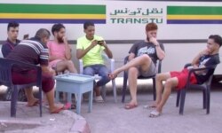 FILE - Young men are seen at a bus stop cafe in Tunis, Tunisia. Unemployment reaches 30 percent in some parts of Tunisia. (Lisa Bryant/VOA)