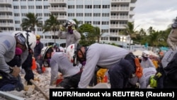 搜救队员6月29日在佛罗里达瑟夫塞德（Surfside）一座部分坍塌的公寓楼现场搜寻。（路透社照片）