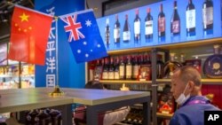 A visitor wearing a face mask to protect against the coronavirus looks at a display of Australian wines at the China International Import Expo (CIIE) in Shanghai on Nov. 5, 2020. (AP)
