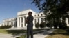FILE - A Federal Reserve police officer keeps watch while posted outside the Federal Reserve headquarters in Washington, Sept. 16, 2015.