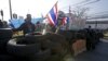 Anti-government protesters wave national flags as they block intersection during rally in Bangkok, Jan. 13, 2014.