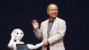 SoftBank Corp. Chief Executive Masayoshi Son (R) waves with the company's human-like robots named 'pepper' during a news conference in Urayasu, east of Tokyo June 5, 2014. 