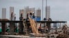 FILE - Construction laborers work at a building site in Bangkok, June 18, 2014.