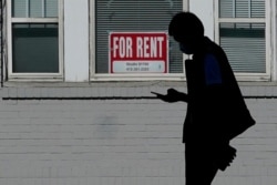 FILE - A man walks in front of a For Rent sign in a window of a residential property in San Francisco, Oct. 20, 2020.