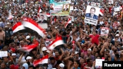 Para anggota Ikhwanul Muslimin dan para pendukung Presiden terguling Mohamed Morsi meneriakkan slogan dalam aksi protes di lapangan Rabaa Adawiya, dimana mereka kemah di kota Nasr, sebelah Timur Kairo (11/8).
