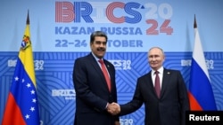 Presiden Venezuela Nicolas Maduro (kiri) menjabat tangan Presiden Rusia Vladimir Putin di sela KTT BRICS di Kazan, Rusia, pada 23 Oktober 2024. (Foto: Alexander Nemenov/Pool via Reuters)