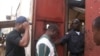 FrontPage Africa editor Rodney Sieh (in back) entering Monrovia Central Prison