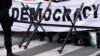 FILE - A pro-democracy banner is pictured during a protest in Brussels, Belgium, Oct. 19, 2018. The Biden administration is sponsoring a virtual Summit for Democracy to be held Dec. 9-10.