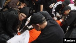 Protesters perform a simulation of the waterboarding torture technique on a man dressed as a prisoner during a protest, marking the fifth anniversary of the U.S.-led invasion of Iraq, in front of the White House in Washington, March 19, 2008. 