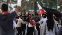 An anti-government protester in Bahrain is carried to a vehicle to be taken to a hospital after being shot Friday during a demonstration in Manama