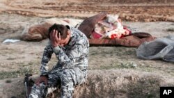 15일 이라크 경찰이 최근 탈환한 모술 지역에서 시신을 수습하고 있다. 사망자 중 많은 수가 어린이들이다. 