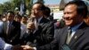 Opposition leader of Cambodia National Rescue Party Sam Rainsy, center, delivers a speech next to his Deputy President Kem Sokha, right, during a gathering to mark Human Rights Day, in front of National Assembly, in Phnom Penh, Cambodia, Wednesday, Dec. 1