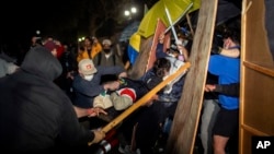 Demonstrators clash at a pro-Palestinian encampment at UCLA early Wednesday, May 1, 2024, in Los Angeles. (AP Photo/Ethan Swope)