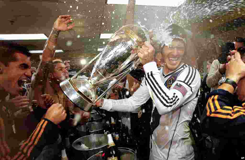 David Beckham disiram sampanye saat tim LA Galaxy merayakan kemenangan 3-1 atas Houston Dynamo dalam kejuaraan MLS Cup di Carson, California, 1 Desember 2012. (AP/Jae C. Hong)
