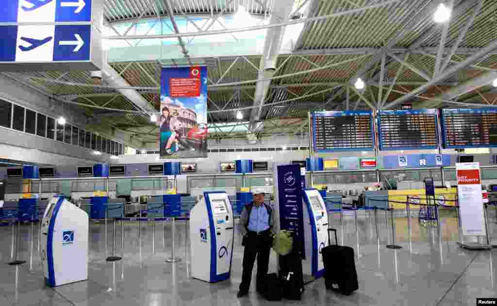 Seorang pria berdiri di tengah-tengah bandara&nbsp;Eleftherios Venizelos yang kosong pada saat berlangsungnya aksi mogok 24 jam di Athena (26/9).