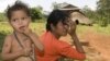 An ethnic minority Cambodian boy, left, stands next to his mother at a village in Mondul Kiri province some 265 kilometers (165 miles) northeast Phnom Penh, file photo. 
