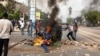 Protesters throw a dumpster on a fire in Dakar, Senegal, June 17, 2022. (Annika Hammerschlag/VOA)
