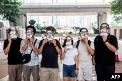 资料照：支持民主的香港跨工会联盟的支持者2021年7月23日在西九龙法院外戴上羊面具抗议。该工会成员现在因“羊村”系列儿童绘本被警方国安处人员拘捕，指控他们涉嫌“串谋刊印、发布、分发、展示或复制煽动刊物”罪。