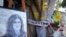 FILE: Yellow tape marks bullet holes on a tree and a portrait and flowers create a makeshift memorial, May 19, 2022, where Palestinian-American Al-Jazeera journalist Shireen Abu Akleh was killed in the West Bank city of Jenin.