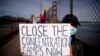 A protester holds up a "Close The Concentration Camps Now" sign after marching across the Golden Gate Bridge during a demonstration against the 2022 Beijing Winter Olympic Games, in San Francisco, California on Feb. 3, 2022.