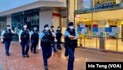 今年7-1刺警案一周年，大批穿上防刺背心、苛枪实弹的军装警员在事发地点铜锣湾崇光百货正门外巡逻。 (美国之音 汤惠芸)