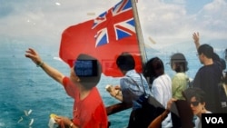 1997年主权移交前的渡轮上，摄影师朱迅拍摄到善信们向天向海撤冥纸，是否祈求神明保佑香港？ (美国之音/汤惠芸）