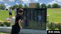 一位悼念者在刻有176位逃港罹难知青名字的碑前。（美国之音记者方冰拍摄，2022年6月15日）