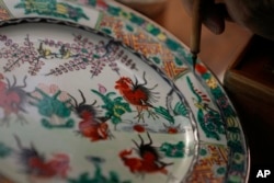 Joseph Tso, owner of Yuet Tung China Works, Hong Kong's last hand-painted porcelain factory, re-paints an old porcelain in Hong Kong, Wednesday, June 8, 2022. .(AP Photo/Kin Cheung)