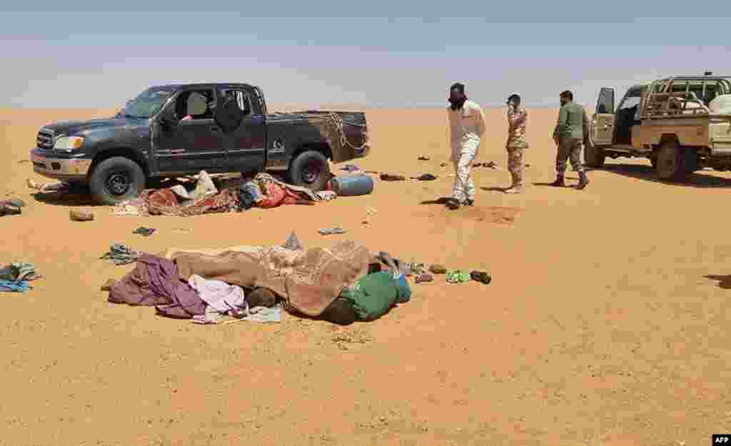 A handout picture provided by the Libya Ambulance Service, June 29, 2022, shows rescuers recovering bodies of migrants found in the Libyan desert, in the southeastern region of Kufra near the border with Chad. 