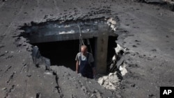 一名男子在检查乌克兰东部顿涅茨克的一所医院被炸毁的屋顶。（2022年6月14日）