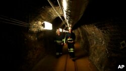 Two researchers walk through an old mining tunnel to what is now the Sanford Underground Research Facility in Lead, South Dakota, on Dec. 8, 2019. The laboratory houses a dark matter detector. 