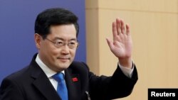 资料照片：2023年3月7日，中国外交部长秦刚参加全国人民代表大会期间新闻发布会时挥手致意。（路透社照片）